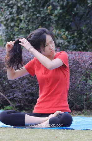 修长身材红T恤美女草地上练起了瑜伽