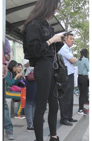 等车的黑衣牛仔裤美女