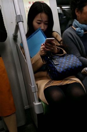 地铁玩手机的米色外套黑色丝袜OL美眉
