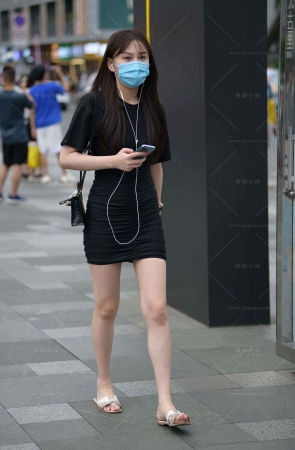 街拍听歌的黑色包臀裙小妞