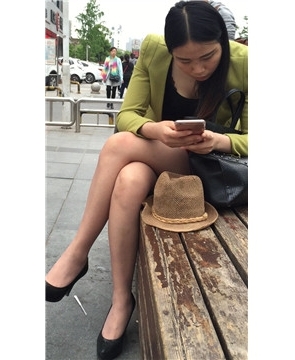 街拍性感高跟短裙美腿美女花坛边休息。