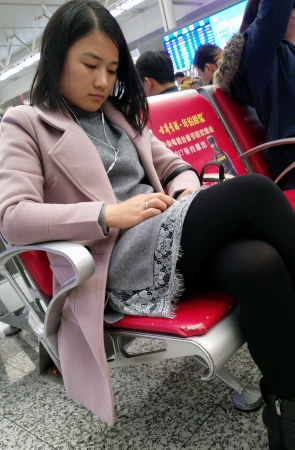 高铁站候车的黑色丝袜灰色连衣裙皮鞋少妇